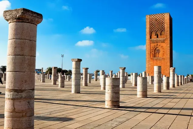 The historic Hassan Tower in Rabat, Morocco, an unfinished minaret from the 12th century, standing tall against a clear blue sky.