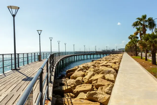 A scenic view of La Corniche in Casablanca, Morocco, featuring a palm-lined promenade along the Atlantic coast with vibrant cafés, restaurants, and the ocean in the background.