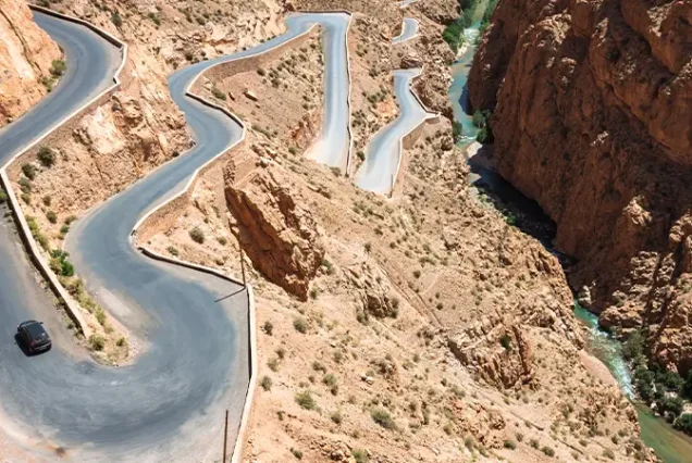 Scenic view of the winding road through the dramatic landscapes of Dades Valley, a highlight of a luxury tour in Morocco.