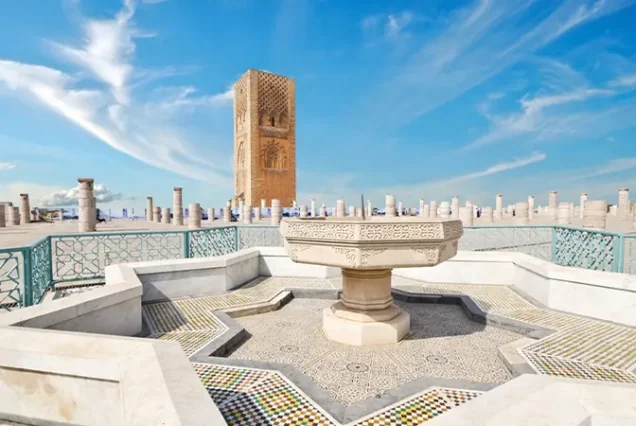 Majestic view of the Hassan Tower in Rabat, Morocco, rising against a vibrant blue sky, symbolizing the city's rich historical heritage.